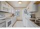 Bright kitchen with white cabinets, appliances, and a convenient double sink at 57 Hadley St, Mooresville, IN 46158