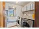 Convenient laundry room with washer, dryer, storage cabinets and a view of the outdoors at 57 Hadley St, Mooresville, IN 46158