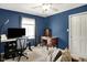 Bedroom or office featuring modern desk, comfortable seating, ceiling fan and blue walls at 601 Shady Ln, Greenwood, IN 46142