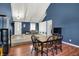 Stylish dining area with hardwood floors, blue walls, vaulted ceiling, and open to living room at 601 Shady Ln, Greenwood, IN 46142