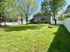 Large grassy backyard enclosed with white vinyl fencing and mature trees at 6360 E Chapel Hill Ct, Camby, IN 46113