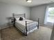 Inviting bedroom with an iron bed frame, neutral carpet, and soft natural lighting at 6360 E Chapel Hill Ct, Camby, IN 46113