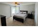 Cozy bedroom showcasing a comfortable bed with plush bedding, a ceiling fan, and natural light from the windows at 6360 E Chapel Hill Ct, Camby, IN 46113