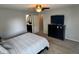 Spacious bedroom with a well-lit ceiling fan, television on a dresser, and convenient access to the bathroom at 6360 E Chapel Hill Ct, Camby, IN 46113
