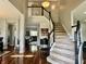 Grand foyer with hardwood floors, staircase, and views into the living room, creating an inviting entrance at 6360 E Chapel Hill Ct, Camby, IN 46113