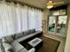 Relaxing sunroom featuring patio furniture, a ceiling fan, white curtains, and a view into the home gym at 6360 E Chapel Hill Ct, Camby, IN 46113