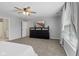 Carpeted bedroom features a ceiling fan, dresser, and large window at 7163 Cordova Dr, Indianapolis, IN 46221
