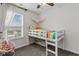 A bright bedroom with a colorful loft bed sits beneath a ceiling fan and beside a window at 7163 Cordova Dr, Indianapolis, IN 46221