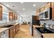 Bright kitchen featuring wood cabinets, stainless steel appliances, and an open view to the dining area at 7163 Cordova Dr, Indianapolis, IN 46221