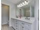 Bathroom boasts a double sink vanity with a decorative mirror and a view of the shower at 7202 Red Lake Ct, Indianapolis, IN 46217