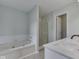 Bathroom features a soaking tub, a glass door shower, white vanity, and neutral walls at 7202 Red Lake Ct, Indianapolis, IN 46217