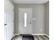 Bright entryway with a decorative white front door, light gray walls, and modern gray hardwood floors at 7202 Red Lake Ct, Indianapolis, IN 46217