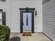 Close-up of a stylish light blue front door with black trim and house number displayed, plus autumn-themed welcome mat at 7202 Red Lake Ct, Indianapolis, IN 46217