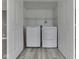A laundry room with white washer and dryer, overhead shelving, and gray floors, hidden behind closet doors at 7202 Red Lake Ct, Indianapolis, IN 46217