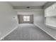 Expansive living room with gray carpet, light gray walls and ample natural light with view of staircase in distance at 7202 Red Lake Ct, Indianapolis, IN 46217