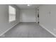 Well-lit living room with gray carpet, light gray walls, and a window for natural light, leading into kitchen at 7202 Red Lake Ct, Indianapolis, IN 46217