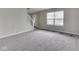 Bright living room with gray carpet and light gray walls, showcasing a staircase and large windows at 7202 Red Lake Ct, Indianapolis, IN 46217