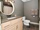 Bathroom with a round mirror, granite countertop, and neutral wallpaper at 728 Christin Ct, Plainfield, IN 46168