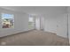 Sunlit bedroom with neutral carpet, two bright windows overlooking a green space, and an en-suite bathroom entrance at 7417 Waylon Way, Indianapolis, IN 46239