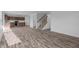 Open-concept room with plank floors and a staircase, flowing seamlessly into the kitchen area at 7417 Waylon Way, Indianapolis, IN 46239
