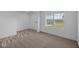 Bright living room featuring plush carpet and large window for natural light at 7417 Waylon Way, Indianapolis, IN 46239