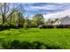Expansive backyard featuring a lush lawn and mature trees, creating a private and serene outdoor space at 7423 Scarborough Blvd E Dr, Indianapolis, IN 46256