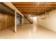 Unfinished basement with visible ceiling beams and stairs leading to the upper level at 7423 Scarborough Blvd E Dr, Indianapolis, IN 46256