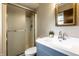 This renovated bathroom features a new vanity and a standup shower with frosted sliding door at 7423 Scarborough Blvd E Dr, Indianapolis, IN 46256