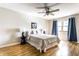 Comfortable bedroom featuring a ceiling fan, hardwood floors, and natural light from the window at 7423 Scarborough Blvd E Dr, Indianapolis, IN 46256