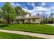 Charming two-story home featuring a stone facade, covered porch, well-manicured lawn, and lush landscaping at 7423 Scarborough Blvd E Dr, Indianapolis, IN 46256