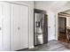Kitchen featuring a stainless steel refrigerator, white cabinetry, and convenient access to the adjacent dining area at 7423 Scarborough Blvd E Dr, Indianapolis, IN 46256