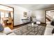 Open-concept living room with hardwood floors, area rug and seamless flow into adjacent dining area at 7423 Scarborough Blvd E Dr, Indianapolis, IN 46256