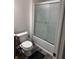 Bathroom with a frosted glass shower door, toilet and grey floors at 7522 Timberfield Ln, Indianapolis, IN 46259