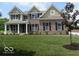Charming two-story brick home with a well-manicured lawn, black shutters, and classic architectural details at 7522 Timberfield Ln, Indianapolis, IN 46259
