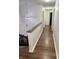 Hallway with hardwood floors, white walls and chandelier lighting at 7522 Timberfield Ln, Indianapolis, IN 46259