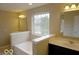Main bathroom with dual sinks, tub, and large window at 7522 Timberfield Ln, Indianapolis, IN 46259