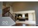 Open concept living space with staircase, hardwood floors, an island and dark cabinets at 7522 Timberfield Ln, Indianapolis, IN 46259