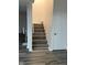 Simple staircase showcasing gray wood-look steps, white trim, and a white wall at 7522 Timberfield Ln, Indianapolis, IN 46259