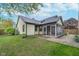 The rear exterior view reveals the back of a cute home complete with lawn and enclosed porch at 7856 Trotwood Cir, Indianapolis, IN 46256