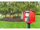 Community library box next to an outdoor bench and plenty of lush greenery at 7856 Trotwood Cir, Indianapolis, IN 46256