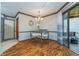 Bright dining area featuring wood floors, modern chandelier, and a sliding glass door to the backyard at 7856 Trotwood Cir, Indianapolis, IN 46256