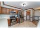Cozy kitchen with stainless steel appliances, wooden cabinets, and view to the laundry room at 7856 Trotwood Cir, Indianapolis, IN 46256