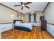 Spacious main bedroom with hardwood floors, ceiling fan, and natural light from the windows at 7856 Trotwood Cir, Indianapolis, IN 46256