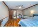 Bedroom featuring a ceiling fan, hardwood flooring, and a workstation for modern living at 7856 Trotwood Cir, Indianapolis, IN 46256