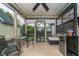 Enclosed porch with outdoor seating, fan, and mini fridge for beverages at 7856 Trotwood Cir, Indianapolis, IN 46256
