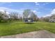 Expansive backyard with green grass, a trampoline, and mature trees under a bright blue sky at 8031 Edgewood Ct, Plainfield, IN 46168