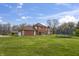 Spacious backyard with house, trampoline, blue skies, and grass at 8031 Edgewood Ct, Plainfield, IN 46168