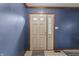 Neutral-toned front door with glass panes against a blue accent wall at 8031 Edgewood Ct, Plainfield, IN 46168
