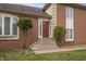 Inviting front entrance featuring a red door, brick facade, and well-maintained landscaping at 8031 Edgewood Ct, Plainfield, IN 46168