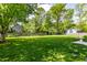 Expansive backyard featuring lush green grass and mature trees creating a serene outdoor oasis at 845 W 77Th St S Dr, Indianapolis, IN 46260